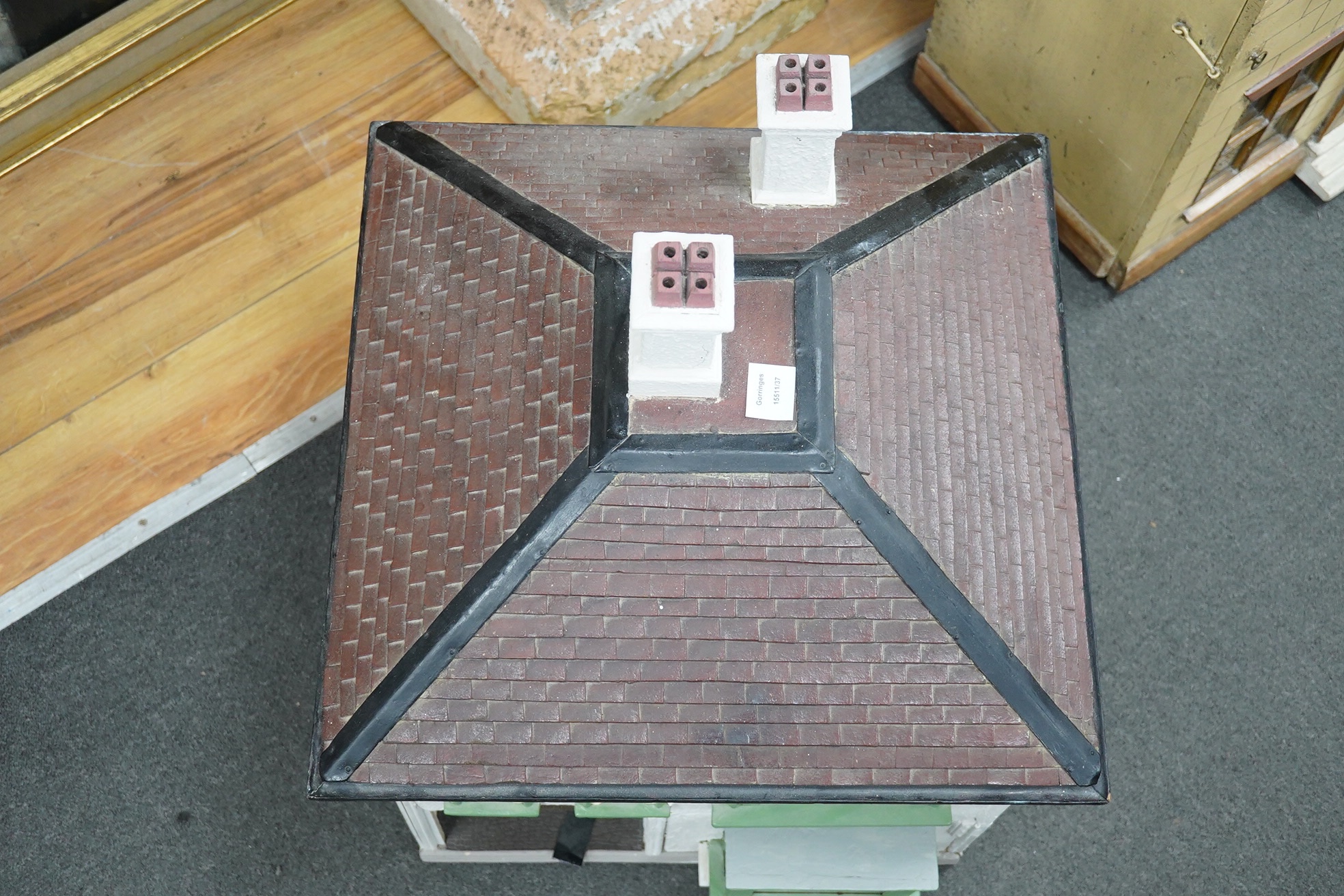 A mid-20th century green and white plywood doll's house, with a pyramid hip tiled roof, together with some plywood furniture including furniture from the Pit-A-Pat Series, height 67cm, width 54cm, depth 54cm. Condition -